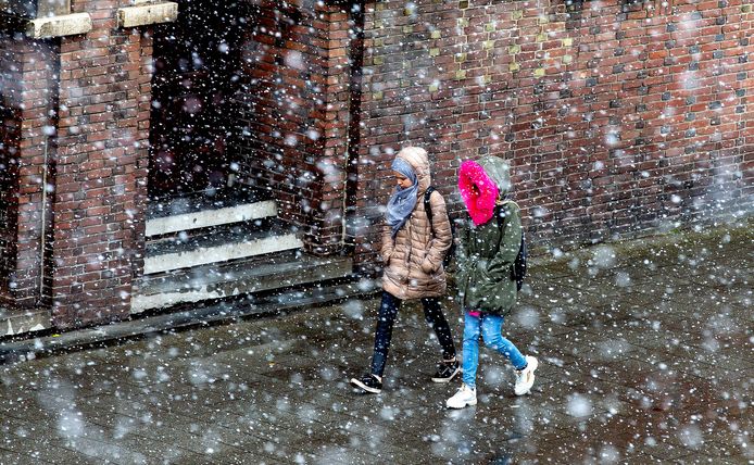 Twee kinderen trotseren een sneeuwbui
