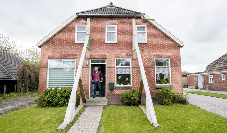 Een Groninger voor zijn beschadigde woning te Loppersum. Beeld ANP
