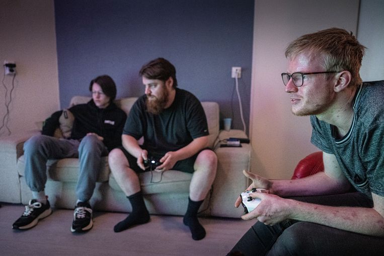 Patrick van Baalen (rechts) speelt een computerspel met Oleksandr. Beeld Koen Verheijden