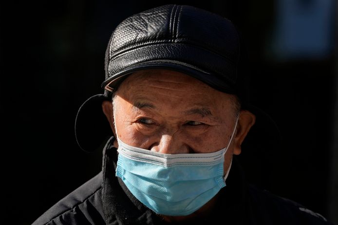 Illustratiefoto van een man met een mondmasker op straat in Peking.