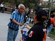 Een man krijgt een flesje koud drinkwater uitgereikt door de dienst burgerbescherming in Monterrey, Mexico, dat momenteel kreunt onder een hittegolf.