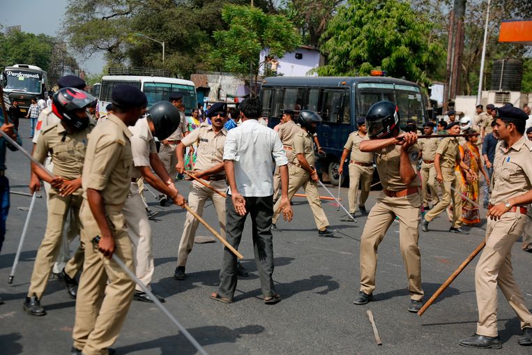 Een dalit gaat in de stad Ahmadabad in de westelijke deelstaat Gujarat in discussie met een politieman terwijl hij door andere agenten wordt geslagen. Dalits staan het laagst op de sociale ladder in India.  Beeld AP