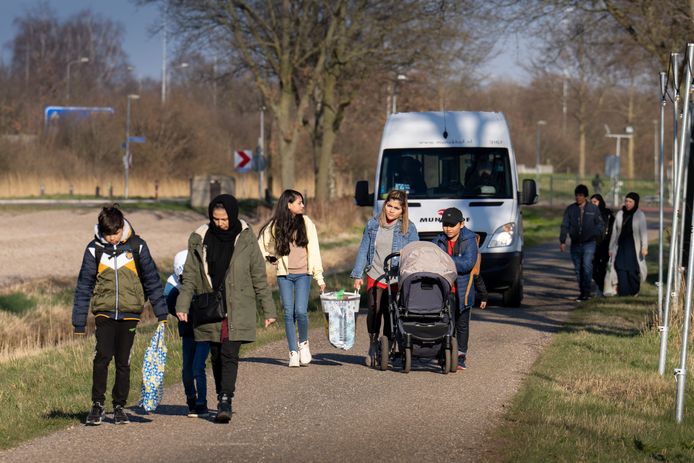 Vluchtelingen op weg naar de noodopvang in het Autotron in Rosmalen.