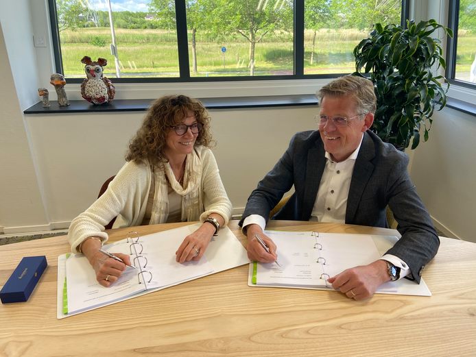 Wiepke van Erp Taalman Kip, directeur-bestuurder SWZ, en Hans Smit, directievoorzitter Koopmans Bouwgroep, tekenen de overeenkomst voor de renovatie en verduurzaming van appartementen aan de Fresiastraat in Zwolle.