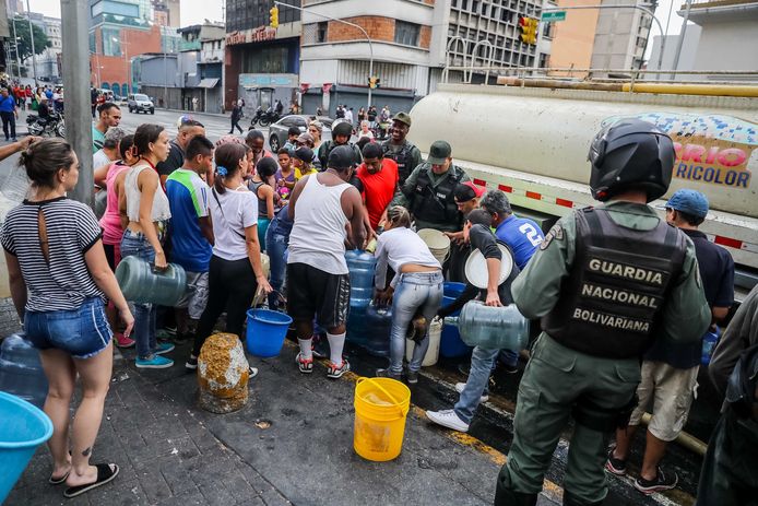 Inwoners van Caracas halen water uit een tank.