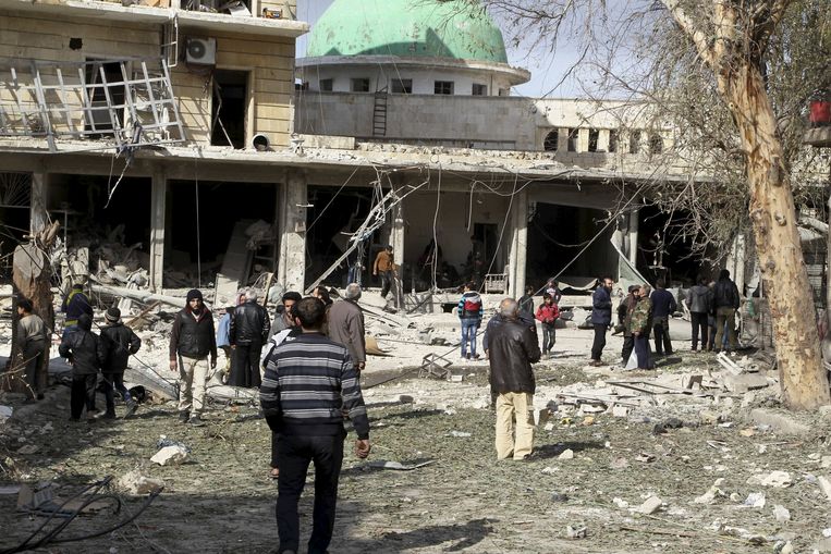 Inwoners meten de schade op na een bombardement op Aleppo door het Syrische leger. Beeld REUTERS