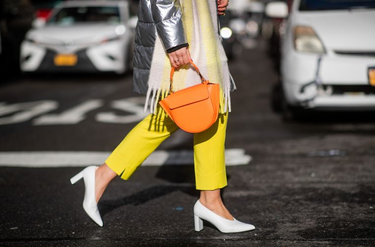 In New York zien we een vrouw met een zilveren Armani jas, een Wandler tas en een gele Victoria Beckham broek. Beeld  Christian Vierig, Getty Images