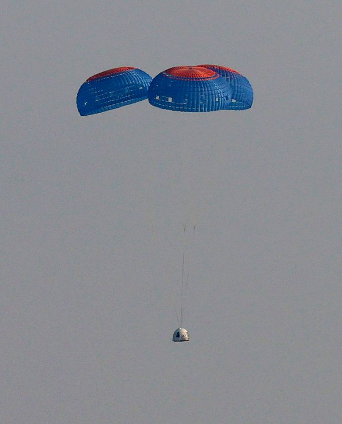 De capsule met aan boord de 4-koppige bemanning keert met behulp van parachutes terug naar aarde.