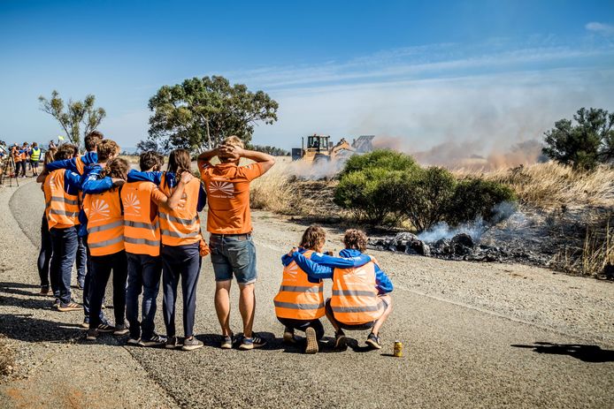 Het Nederlandse team kijkt verslagen toe: van hun auto blijft niets meer over na een felle brand.