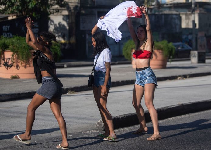 Wanita muda dengan kaos berdarah berdemonstrasi menentang kebrutalan polisi.