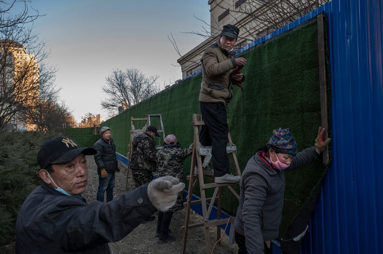 Om een hotel in Peking wordt een hek opgetrokken om de gasten af te schermen van de inwoners van de stad, een van de vele coronamaatregelen voor de Winterspelen.  Beeld Getty