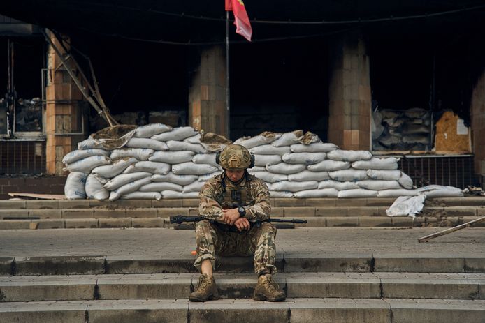 Een Oekraïense soldaat op de trappen van het stadhuis van het bevrijde Izium in Charkiv.