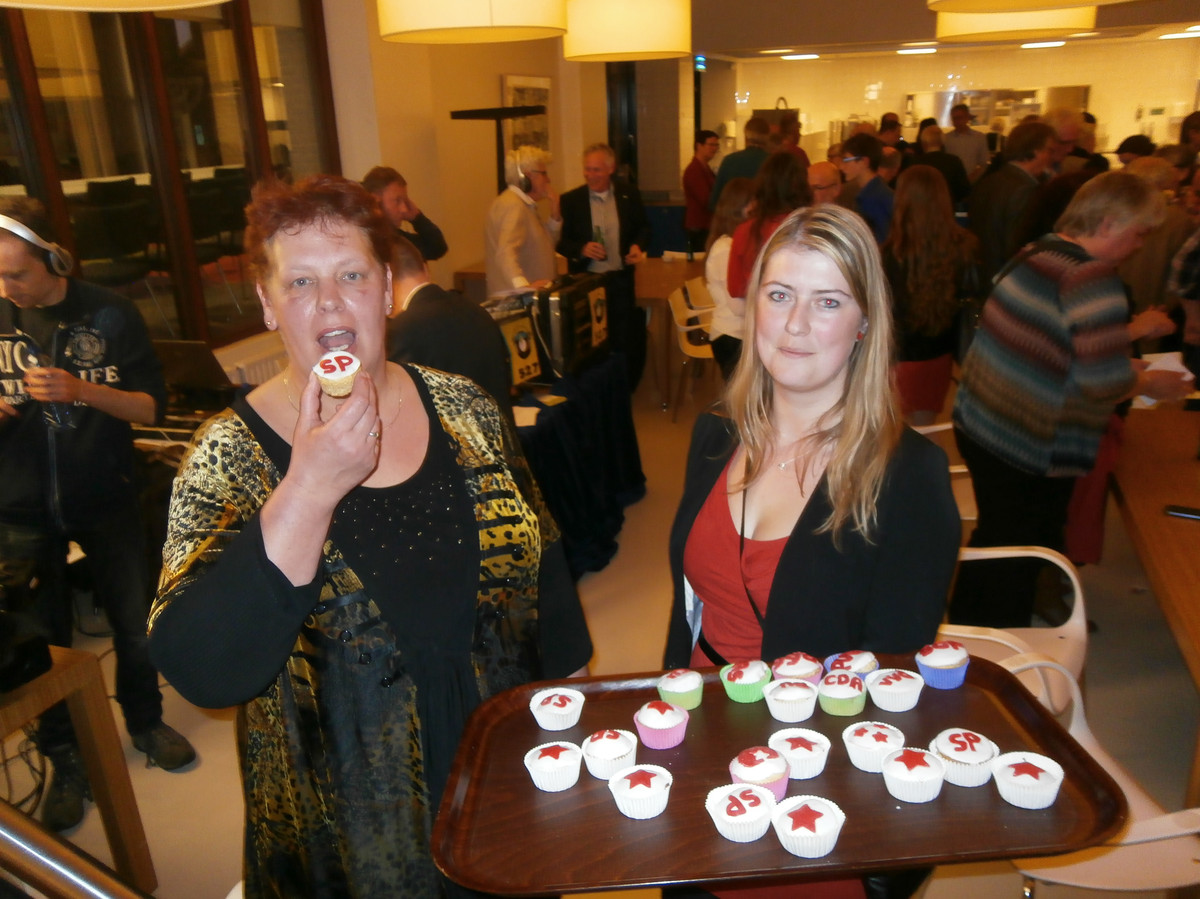 Tjitske Hoekstra viert de overwinning van de SP in 2014 met een cupcakeje, naast het andere raadslid Denise van Sluijs.