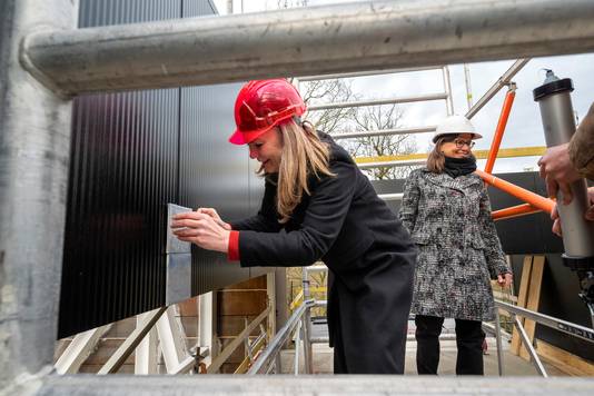 Wethouder Cathelijne Bouwkamp (links), hier met museumdirecteur Saskia Bak bij het plaatsen van de eerste tegels op de buitengevel van het nieuwe Museum Arnhem.