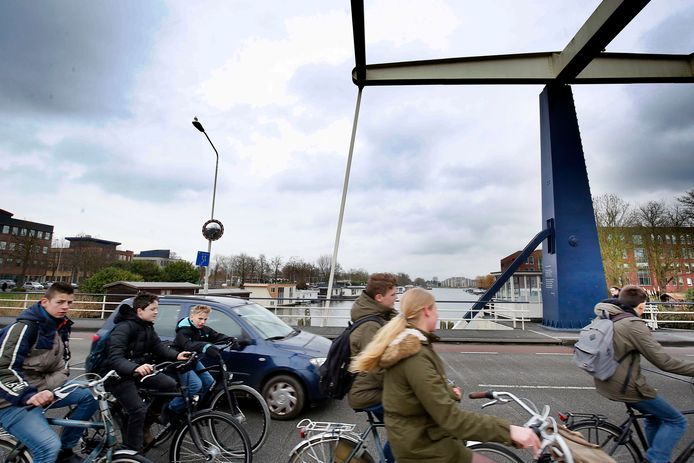 Fietsers en auto's rijden over de Lange Brug richting de binnenstad. Voorbij de kantoren op de linkeroever ligt het station waar een tweede brug over het Kanaal van Steenenhoek moet komen te liggen.