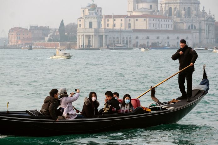 Toeristen met mondmaskers in een gondel in Venetië vrijdag.