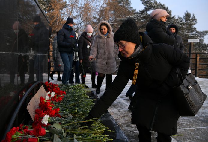 Mensen leggen bloemen neer ter nagedachtenis van de overleden mijnwerkers.