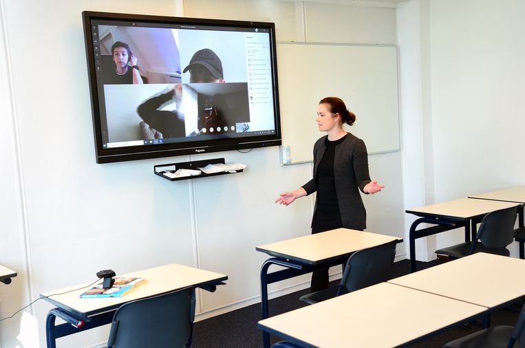 Een docente geeft online les. Na anderhalf jaar van voornamelijk digitaal lesgeven snakken de middelbare scholen en het hoger onderwijs weer naar volle klassen. Beeld Marcel van den Bergh / de Volkskrant