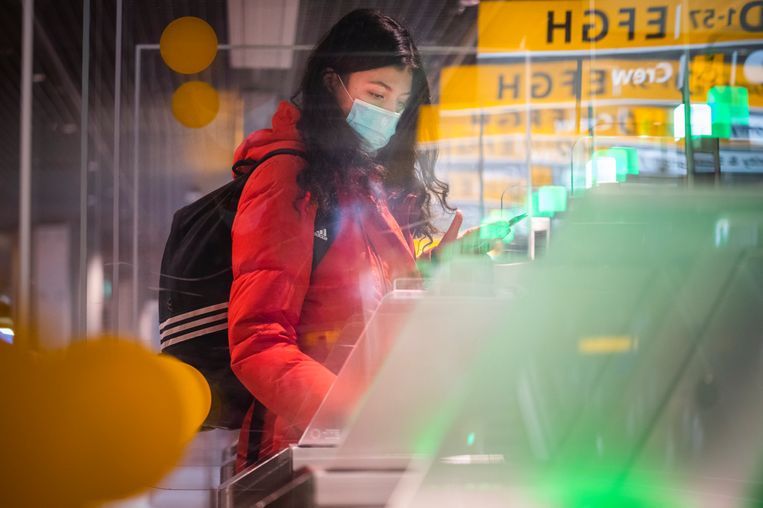 Een vrouw gaat door de poorten naar de douane nadat ze haar ticket heeft gekregen op Schiphol.  Beeld Freek van den Bergh / de Volkskrant