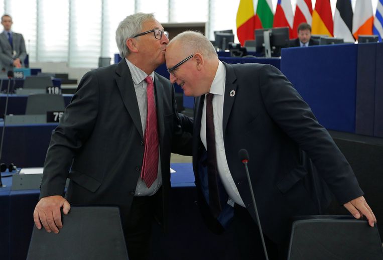 President van de Europese Commissie Jean-Clause Juncker kust Frans Timmermans, eerste vice-president van de Europese Commissie, op zijn voorhoofd als ze aankomen om een debat bij te wonen in Straatsburg. Beeld REUTERS