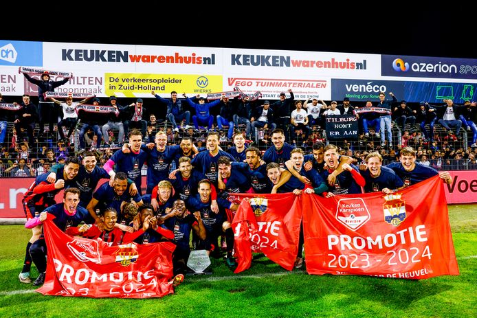 De spelers poseren met de promotievlaggen. De meegereisde Willem II-fans op de achtergrond.