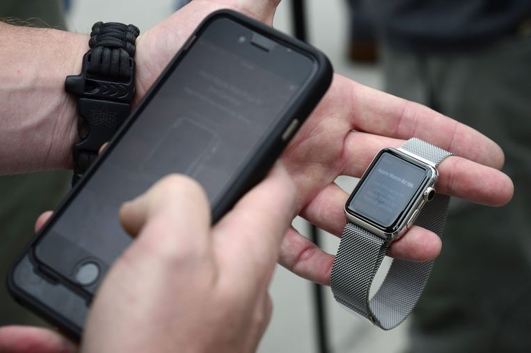 Een man probeert zijn Apple Watch te synchroniseren met zijn iPhone. Beeld EPA