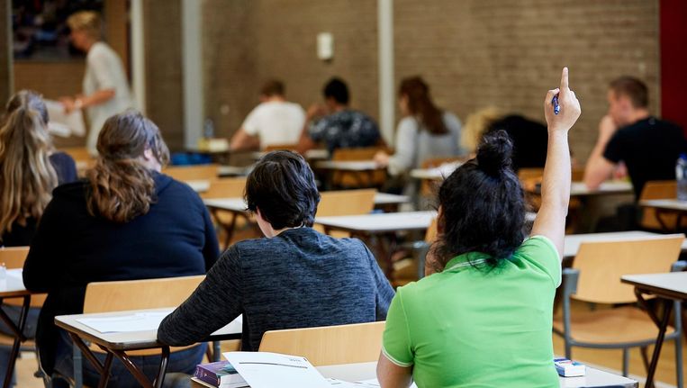 Leerlingen van Havo 5 doen in de gymzaal van hun school eindexamen in het vak Maatschappijwetenschappen. Beeld anp