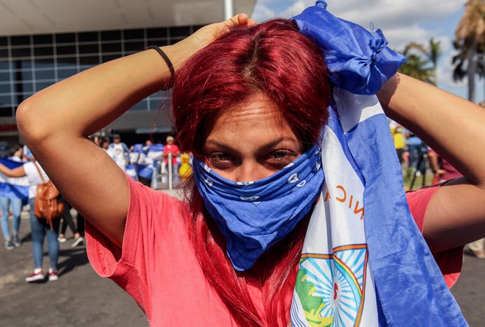 Een demonstrant bindt een doek voor haar gezicht in Nicaragua.