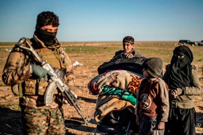 Koerdische strijders van SDF controleren de laatste vluchtelingen uit Baghouz.