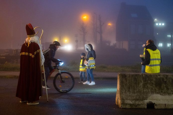 Sinterklaas schenkt chocolade aan goed verlichte fietsers.