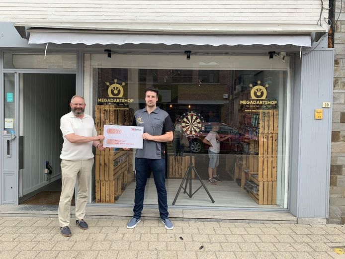 De uitbater van MegaDartShop ontvangt uit handen van schepen Maurice Helsen zijn cheque