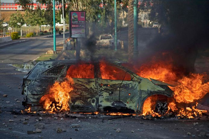 Een Israëlische politiewagen gaat in vlammen op in Lod tijdens rellen.