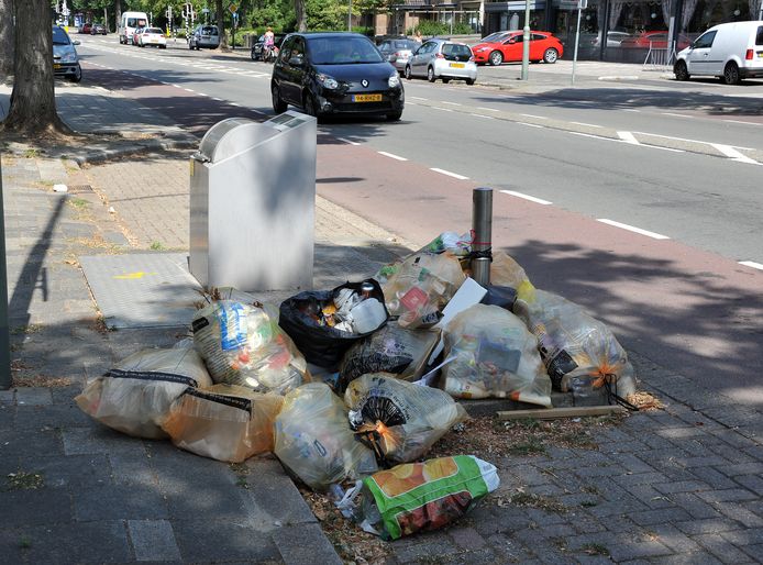 Afval naast een vuilcontainer.