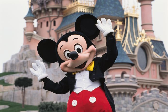 Een acteur als Mickey Mouse voor het kasteel in Disneyland Parijs.