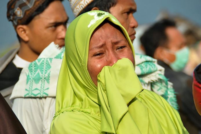 Een vrouw huilt terwijl ze de schade bekijkt die de tsunami en de aardbeving hebben aangericht.