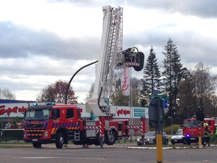 Toen de paal van een verkeerslicht in Turnhout los kwam te hangen, heeft de brandweer het met een ladderwagen verwijdert. Beeld Dirk Van Gorp