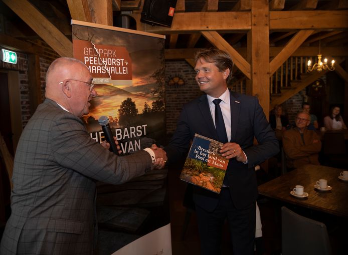 Michiel van Veen neemt het eerste exemplaar van het boek in ontvangst.