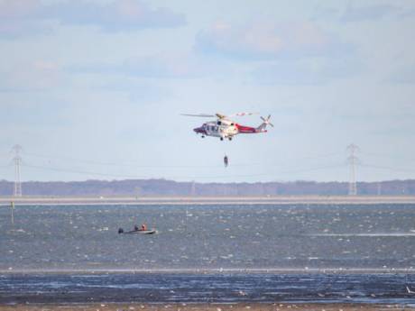 Kustwachthelikopter haalt personen uit bootje in Oosterschelde