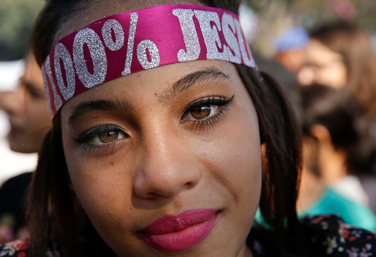 Evangelische christenen in Brazilië komen elk jaar samen voor de Mars voor Jezus in São Paulo. Een van de deelneemsters heeft ‘100% Jezus’ op haar haarband staan.  Beeld AP