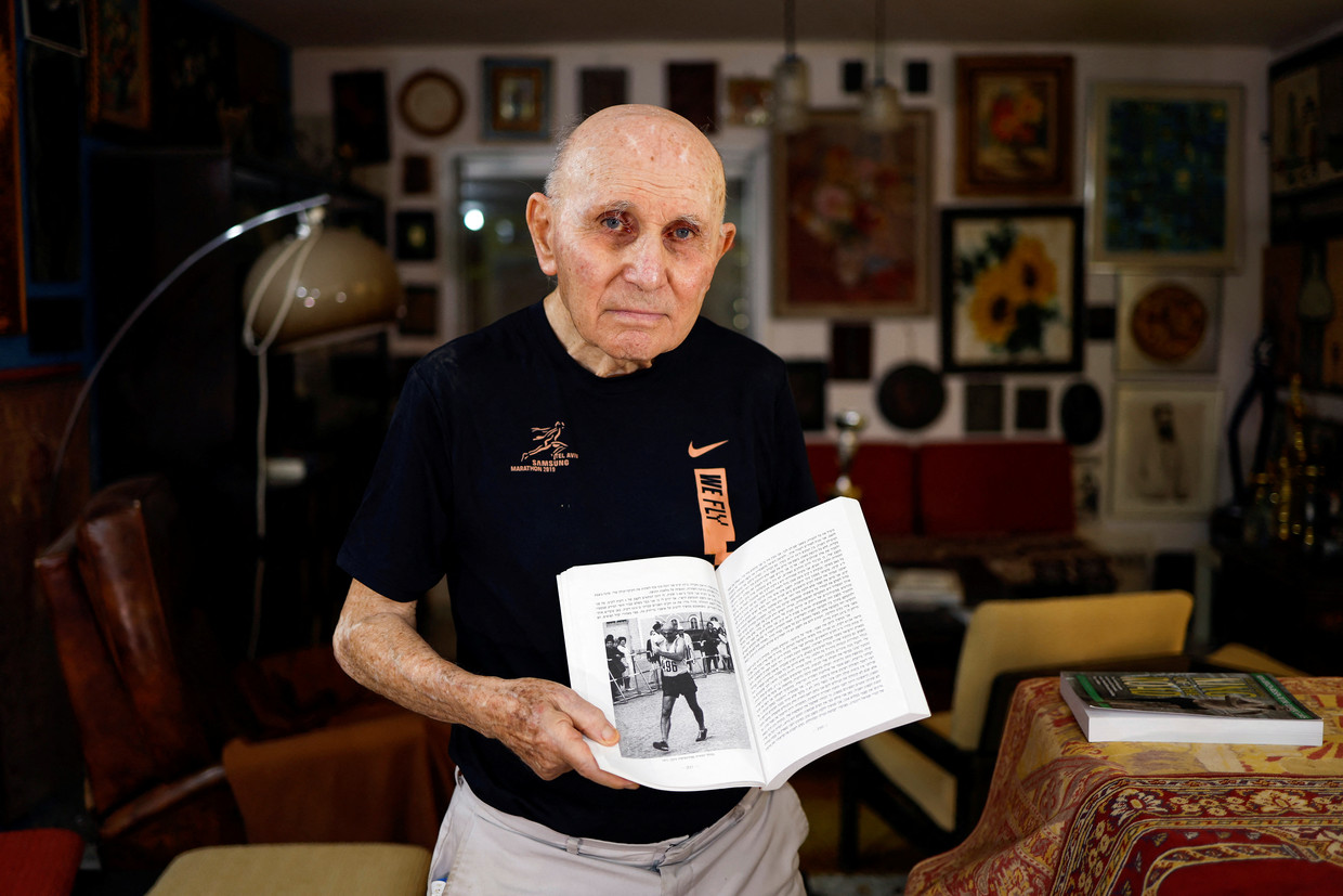Shaul Ladany (86) laat een boek over zijn leven zien in zijn huis in Israël. Beeld REUTERS