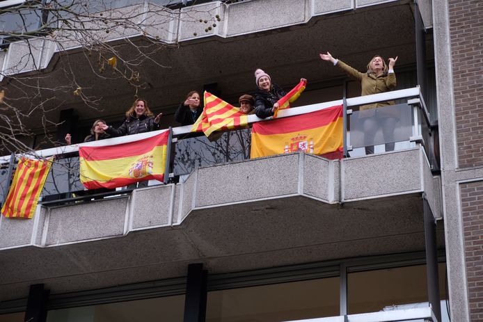 Een klein tegenprotest: enkele vrouwen hebben Spaanse vlaggen opgehangen aan een balkon langs het parcours.