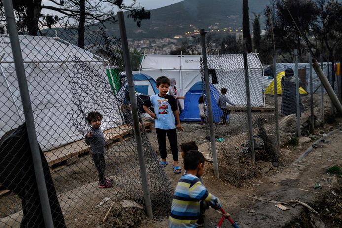 Kinderen spelen naast een hek buiten het vluchtelingenkamp op het Griekse eiland Samos.