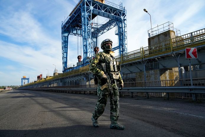 Een Russische soldaat patrouilleert naast een stroomcentrale aan de rivier de Dnepr in de regio Cherson.