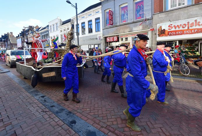 Terwijl moeders met kinderen bij Sep nog gauw wat feestspullekes kopen, blaast de Tullepetaone Kapel er al vrolijk op los. De boeren blazen ook: zij moeten het Turfschip naar de Markt trekken. Een sanitaire stop bij een plaszuil biedt wat soelaas.