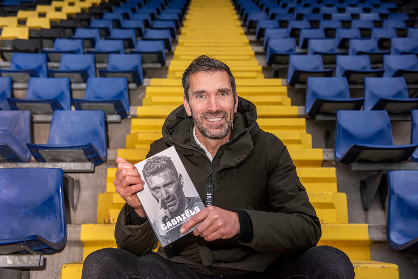 Johan Gabriëls met zijn boek in het NAC-stadion.