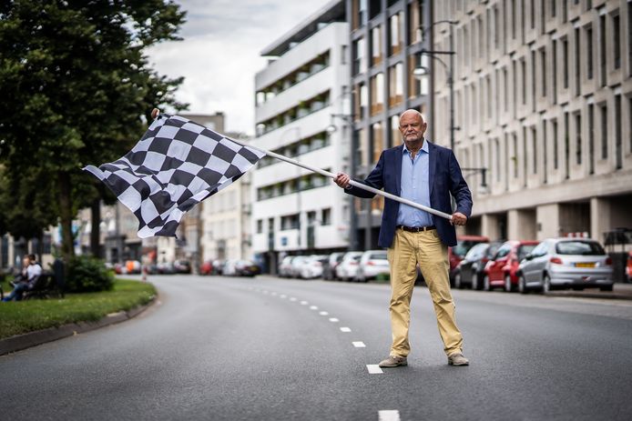 John Holtackers met de zwart-wit geblokte finishvlag die hij uit protest tegen snelheidsduivels op Arnhemse Centrumring aan zijn balkon heeft gehangen.