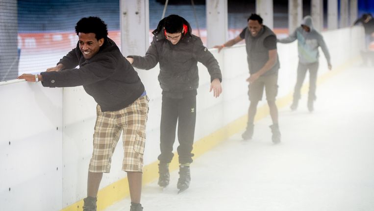 Asielzoekers doen mee aan een Hollandse Koek-en-Zopie schaatsmiddag in De Uithof in Den Haag. Beeld ANP