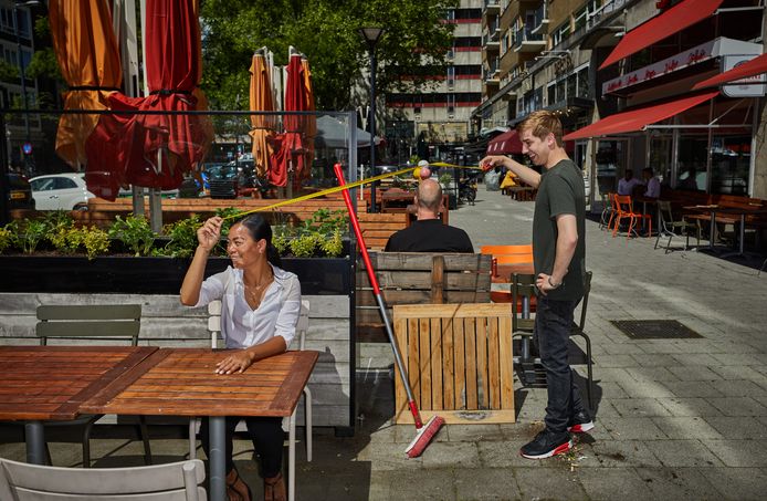 Medewerkers van restaurant Gusto aan de Schiedamse Vest meten de afstand tussen de tafels van hun grote terras.