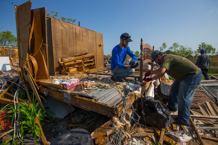 Vrijwilligers uit Abilene verwijderen een bedframe uit een verwoeste woning in Bayside