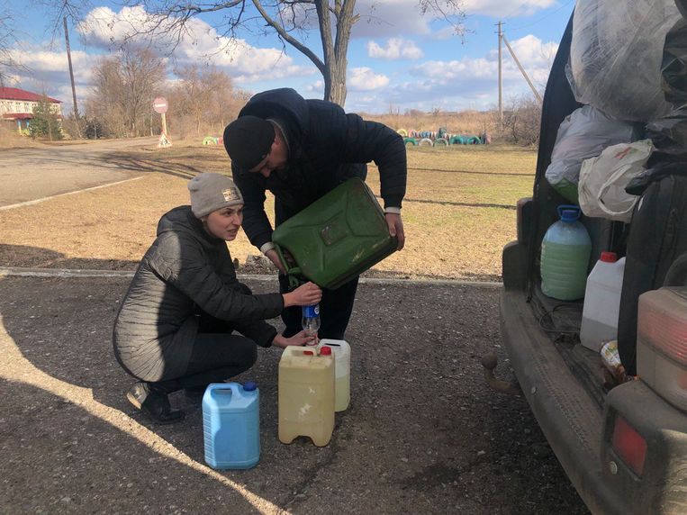 Hulpverleners brengen Aleksandra Hajdoek in Trojtske benzine voor de generator. De stroom viel uit na de beschietingen, vrijdag. Beeld Michiel Driebergen